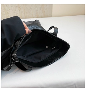 Close-up of black skull tote bag interior showing the silver zippered pocket and lining