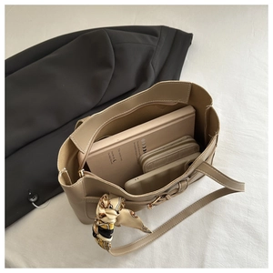 Vue de dessus d'un cabas beige spacieux avec foulard en soie et accessoires du quotidien