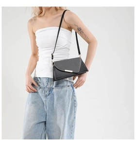 Détail du sac bandoulière enveloppe noir et gris avec boucle en métal doré chic