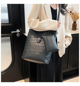 Detail view of black skull embossed leather tote bag with crystal-encrusted metal hardware