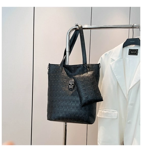 Detail of black embossed skull leather tote bag set with rhinestone skull ornament