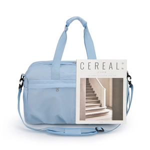 Light blue nylon travel bag with magazine for scale, ideal for gym and fitness