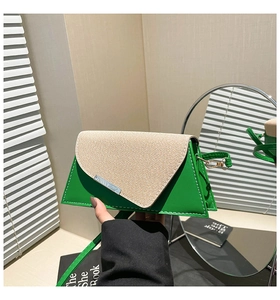 Détail du sac à bandoulière en cuir vert avec rabat en paille tressée et fermoir