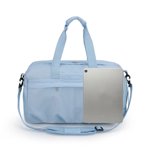 Detailed view of light blue nylon travel bag with shoulder strap and iPad for size reference