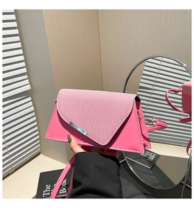 Détail du sac bandoulière rose avec rabat asymétrique et bordure en métal argenté