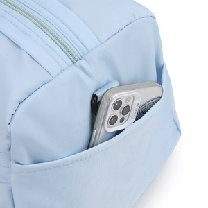 Detail of light blue nylon bag side pocket showing easy smartphone storage