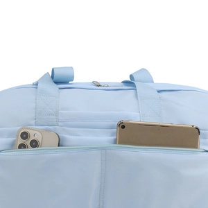 Detail of light blue waterproof nylon travel bag showing zippered pocket capacity for phones