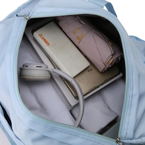Spacious interior of light blue nylon travel bag holding iPad and headphones
