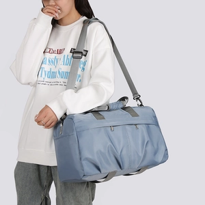 Detail of blue high-capacity nylon travel bag with adjustable straps and multiple pockets