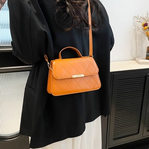 Chic quilted orange crossbody bag with metal accents and chain strap for women