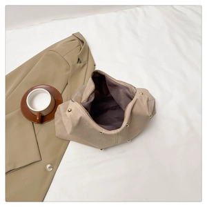 Vue de dessus d'un sac sous les bras en cuir kaki avec clous dorés et doublure violette