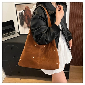 Détail du sac hobo en daim caramel avec clous dorés et design rétro spacieux