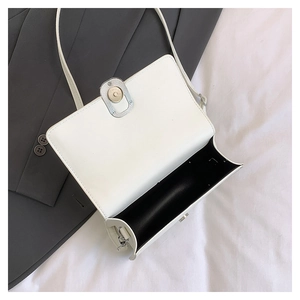 Internal view of a white minimalist crossbody bag showing a spacious black interior