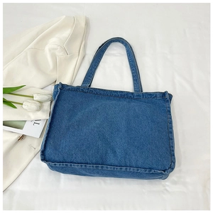 Detail of dark blue denim tote bag with visible stitching and minimalist vintage style