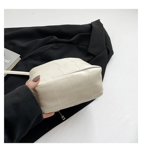 Detailed close-up of the woven leather texture on this minimalist cream shoulder bag