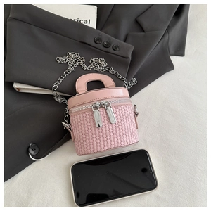 Detail of pink cylindrical woven mini bag with silver chain strap and dual zippers