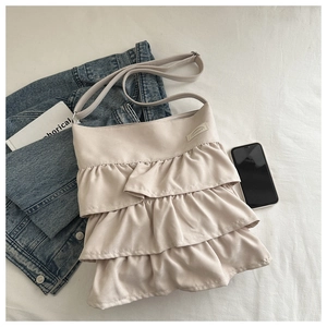 Detail of cream pleated ruffle tote bag with layered frills and adjustable strap