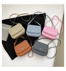 Flat lay of retro crossbody bags in five colors with textured PU leather and flap design