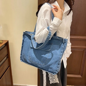 Minimalist navy blue denim tote bag with spacious capacity and front pocket style