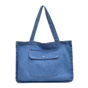 Minimalist denim shoulder tote bag in blue with large front pocket and contrast stitching