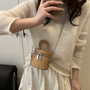 Chic woven cylinder bucket bag with brown leather trim and silver chain shoulder strap