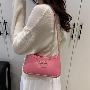 Elegant pink PU leather underarm bag featuring a golden bow buckle for women