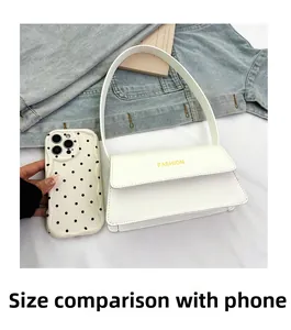Detaillierter Größenvergleich der weißen Schultertasche mit einem Smartphone