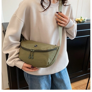 Gros plan sur le sac bandoulière en nylon vert olive avec logo OK et double fermeture