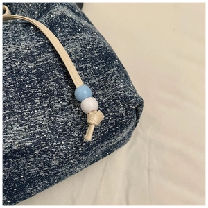 Detail der blauen Jeans-Tasche mit Sternenmuster, Kordelzug und Zierperlen-Verschluss