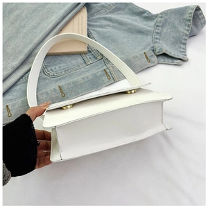 Detail einer stilvollen weißen Lederhandtasche mit weichen Falten und goldenem Knopf