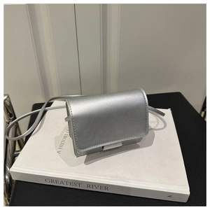 Detail of silver metallic mini crossbody bag showing smooth texture and slim strap