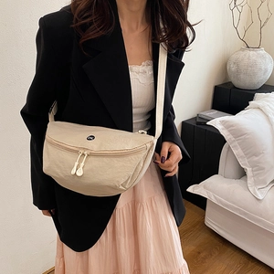Sac bandoulière demi-lune en nylon beige avec logo OK porté par un mannequin