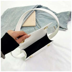 Detailansicht der weißen minimalistischen Handtasche mit goldenem Magnetverschluss
