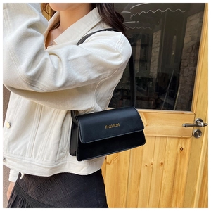 Detailaufnahme der schwarzen Leder-Schultertasche mit goldener Aufschrift