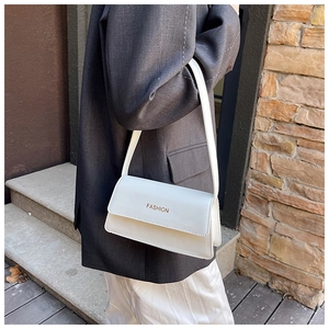 Detailaufnahme der weißen Kunstleder-Schultertasche mit FASHION-Aufdruck und Magnetklappe
