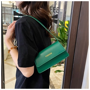 Detail der grünen matten Leder-Schultertasche mit gelbem Fashion-Text und feinen Nähten