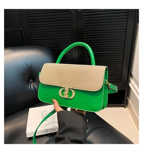 Detail of woven beige flap and green leather luxury handbag with gold interlocking buckle