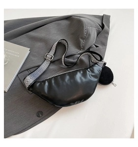 Détail du sac bandoulière noir en demi-lune avec sangle à chevrons et pochette ronde