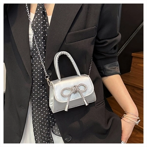 Dettaglio mini borsa argento con fiocco di diamanti e rifiniture in nappa metallica