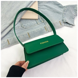 Detail der grünen Kunstledertasche mit gelbem FASHION-Text und schmalem Riemen