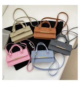 Detail showing five colors of woven texture handbags with gold metal bars and crossbody straps