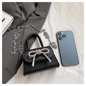 Dettaglio mini borsa nera con fiocco di strass argentati e catena elegante