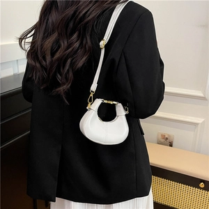 Mini white crescent hobo bag in matte leather worn crossbody with gold hardware