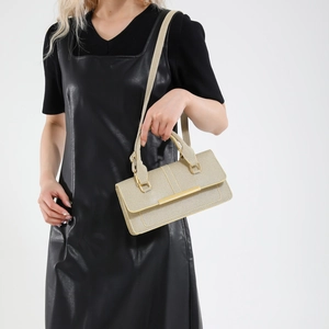 Minimalist beige woven texture handbag with gold metal trim and adjustable strap