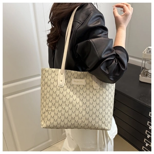 Detail of off-white monogram tote bag with Fashion plaque on a model's shoulder