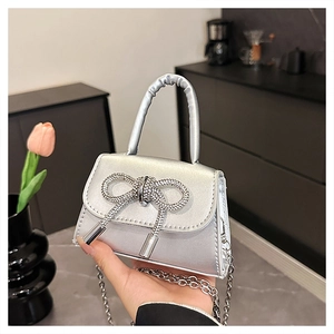 Dettaglio della mini borsa argento con fiocco di strass e catena metallica