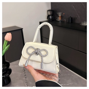 Dettaglio mini borsa bianco crema con fiocco di strass argentati e catenella