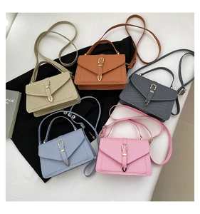 Flat lay of small crossbody square bags in five colors with textured leather and gold buckles