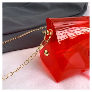 Dettaglio della borsa da spiaggia in PVC rosso trasparente con catena d'oro e moschettone