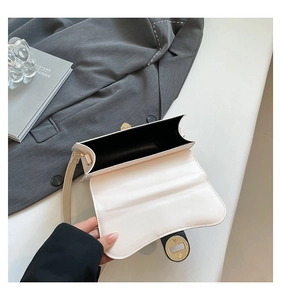 Close-up of ivory leather square bag with metal twist lock and interior structure
